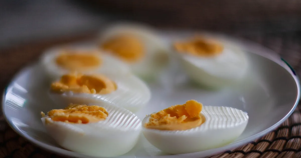 Close-up of sliced boiled eggs with soft yolks on a white plate, perfect breakfast or snack idea.