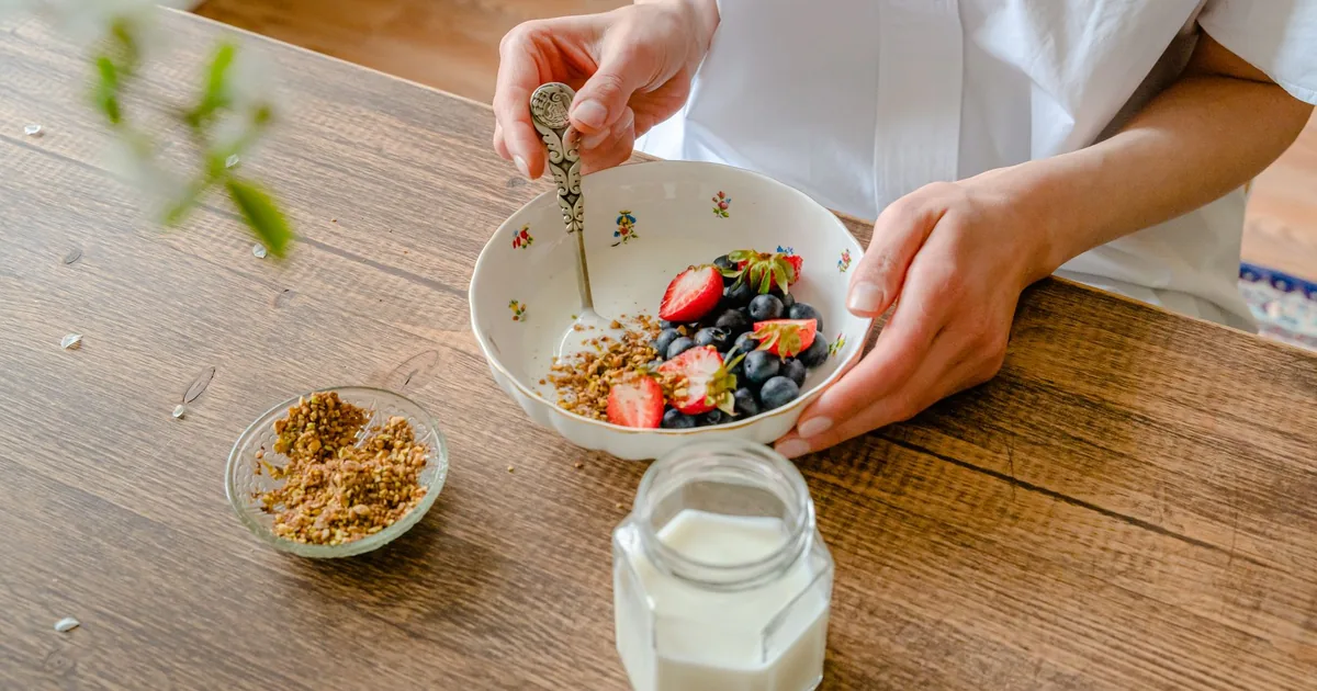 A vibrant homemade yogurt bowl with strawberries, blueberries, and crushed nuts, perfect for a healthy breakfast.
