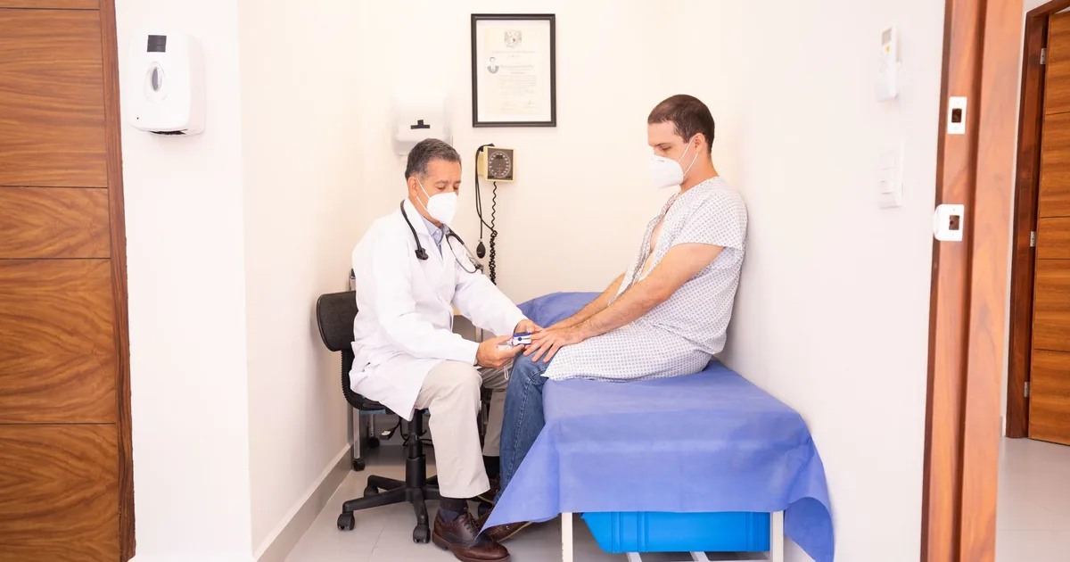 Doctor checking patient's vitals in a clinical setting for health consultation.